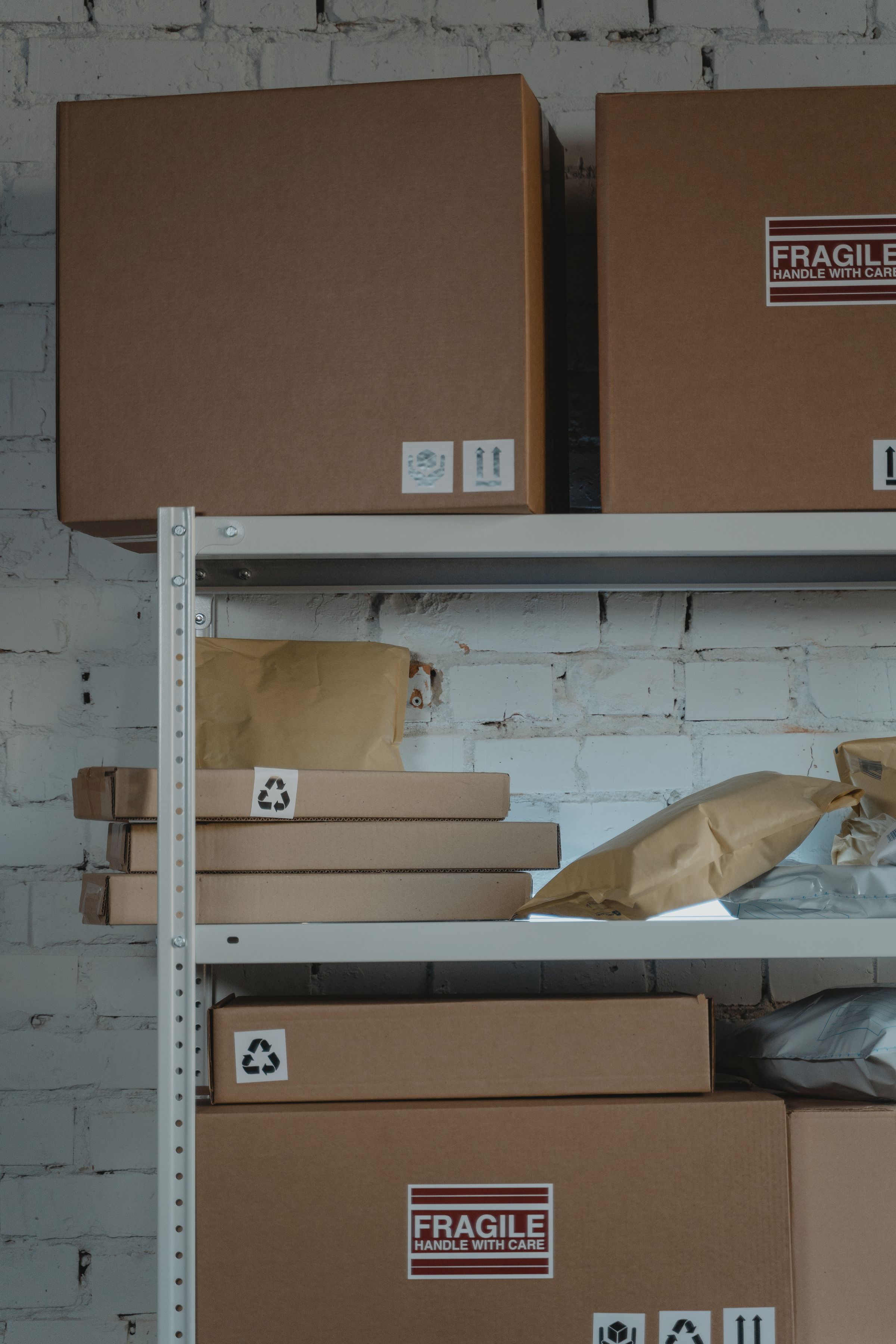 Brown cardboard export cartons stacked on white steel warehouse shelves